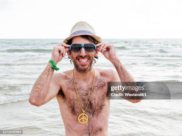 portrait of smiling man with hat and sunglasses on the beach - chest hair stock pictures, royalty-free photos & images