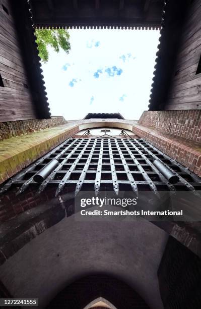 view of the portcullis (vertical sliding gate) of medieval malbork castle in poland - fallgatter stock-fotos und bilder