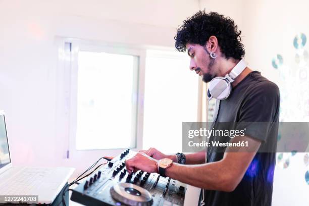 young male musician mixing sound while djing at recording studio - djiang stock pictures, royalty-free photos & images