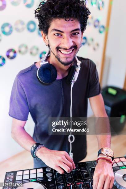 smiling young male musician with sound mixer djing at recording studio - djiang stock pictures, royalty-free photos & images