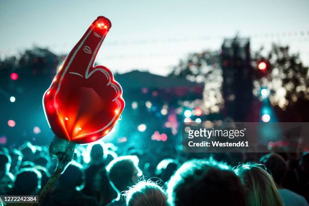 large foam hand over crowd of people having fun during music festival - entertainment music imagens e fotografias de stock