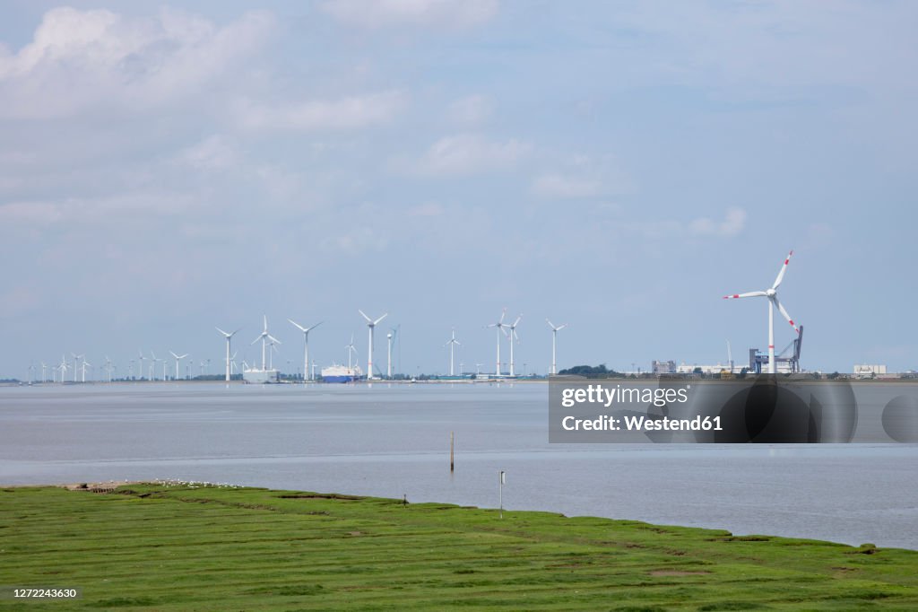 Germany, Lower Saxony, Emden, Wind turbines on bank of Ems