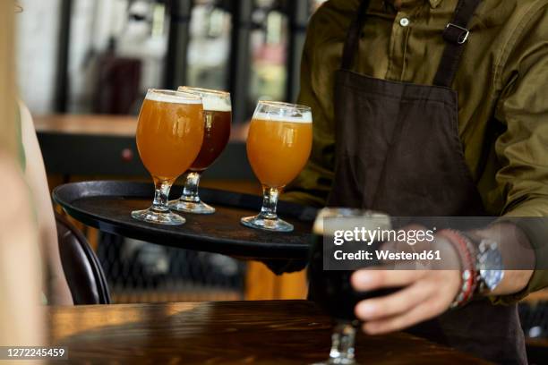 waiter serving variety of craft beer in a pub - cerveza artesanal fotografías e imágenes de stock