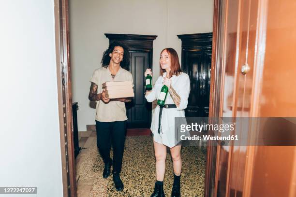 friends with beer bottle and pizza boxes at entrance of home - the party arrivals stock-fotos und bilder