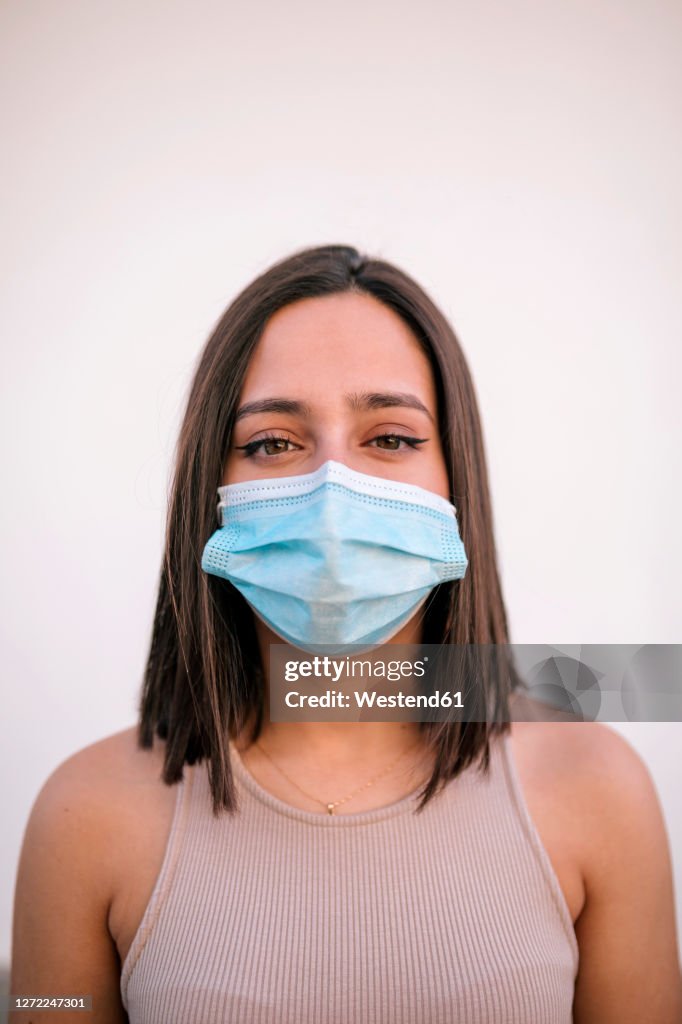 Portrait of beautiful young woman wearing protective face mask