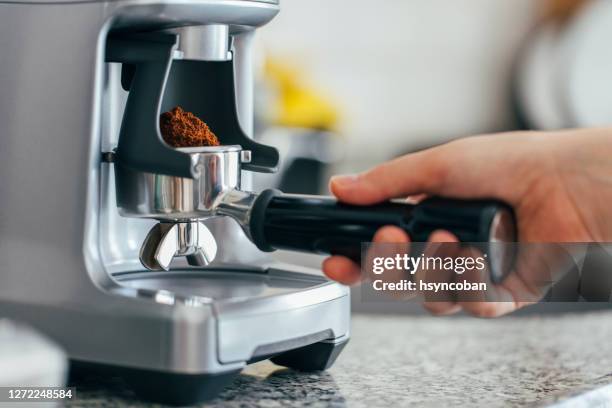 granos de café en un portafiltro de la trituradora de café - molinillo fotografías e imágenes de stock