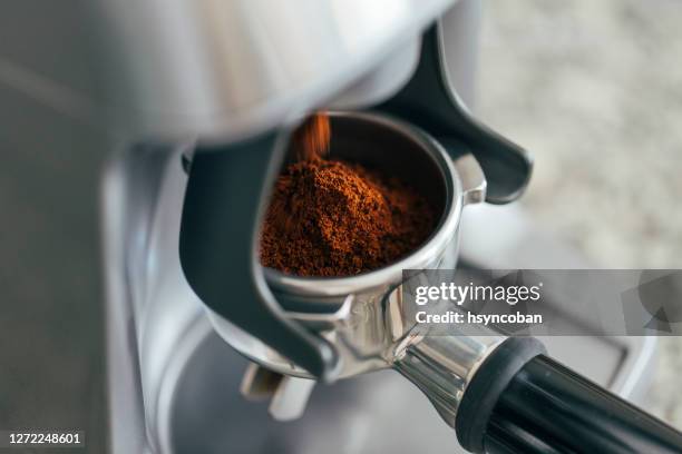 coffee beans in a portafilter by the coffee grinder - grinding stock pictures, royalty-free photos & images