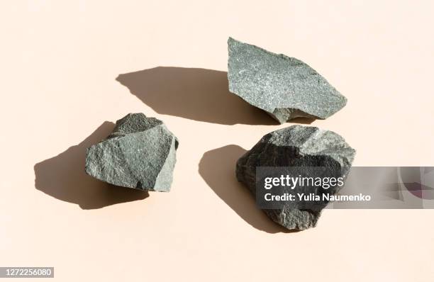 stone podium for cosmetics or products on brown beige background. modern layout presentation pedestal. set of stones. top view, hard shadows. - beige rock fotografías e imágenes de stock