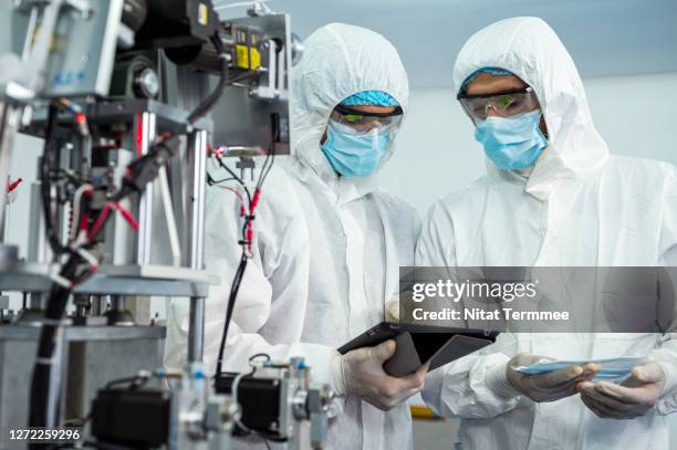 workers inspecting product in medical face mask factory. improve manufacturing productivity - cleanroom stock pictures, royalty-free photos & images