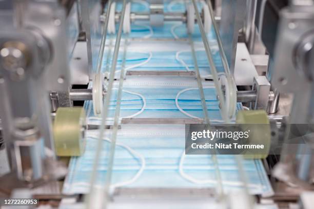 close-up of automatic face mask making machine production line. - making masks stock pictures, royalty-free photos & images