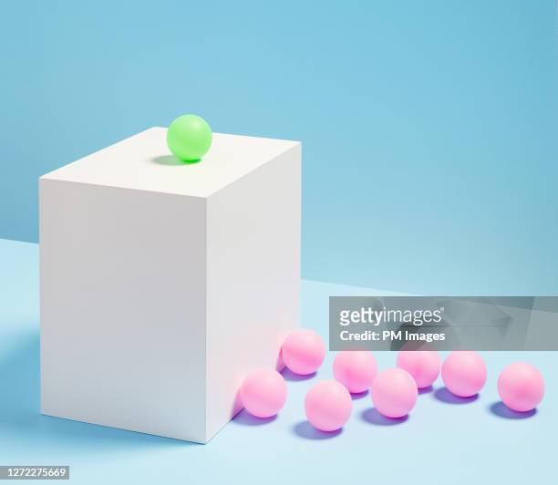 green ball above the crowd of pink balls - exclusion concept stock pictures, royalty-free photos & images