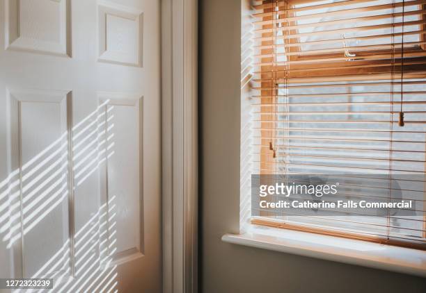 natural wooden window and white door frame with sunbeams shining in - tapparelle foto e immagini stock