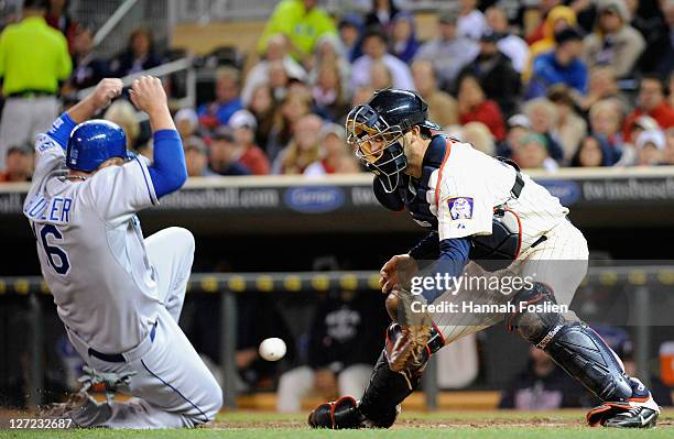 Billy Butler of the Kansas City Royals slides safely as Drew Butera of the Minnesota Twins defends home plate in the sixth inning on September 26,...