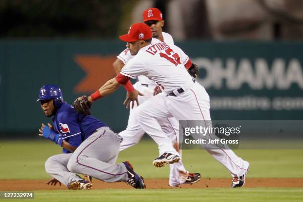 Elvis Andrus of the Texas Rangers is tagged out by second baseman Maicer Izturis of the Los Angeles Angels of Anaheim after being caught in a run...
