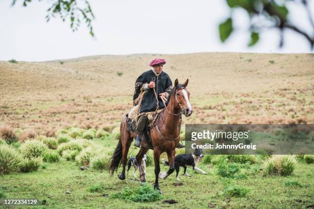 wet young gaucho riding in rain wearing traditional clothing - cordoba argentina stock pictures, royalty-free photos & images