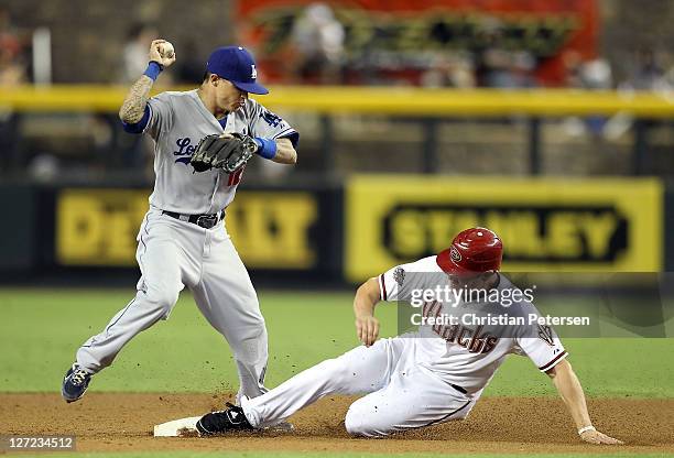 Infielder Justin Sellers of the Los Angeles Dodgers gets the force out at second base on Sean Burroughs of the Arizona Diamondbacks during the eighth...