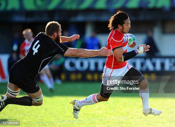 Kosuke Endo of Japan goes past the challenge from Jebb Sinclair of Canada to score his team's second try during the IRB 2011 Rugby World Cup Pool A...