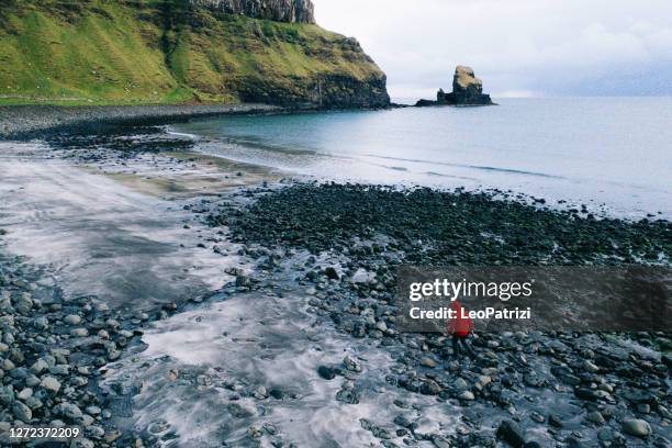 man in talisker bay beach in scotland, uk - rock formation stock pictures, royalty-free photos & images