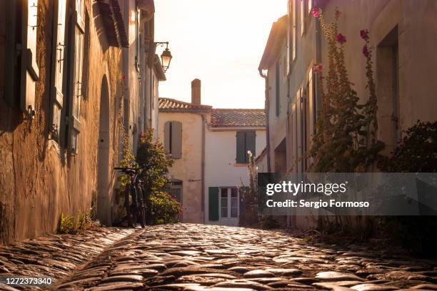 cobblestone street in saint-martin-de-ré, île de ré, france - saint martin stone stock-fotos und bilder