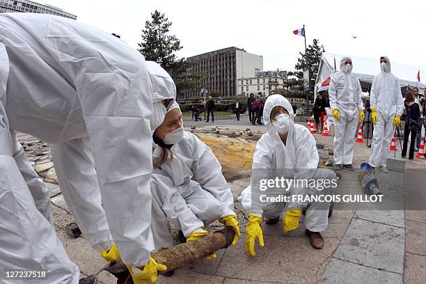 Antinuclear activists pose next to British artist Julian Beever pavement painting of a crater at Place Raoul Dautry infront Tour Montparnasse in...