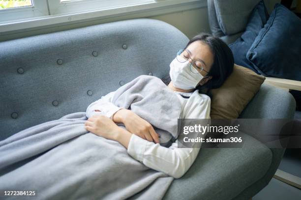 asian business man feeling sick and headache symptoms and sleep on the sofa - infectious mononucleosis stock-fotos und bilder