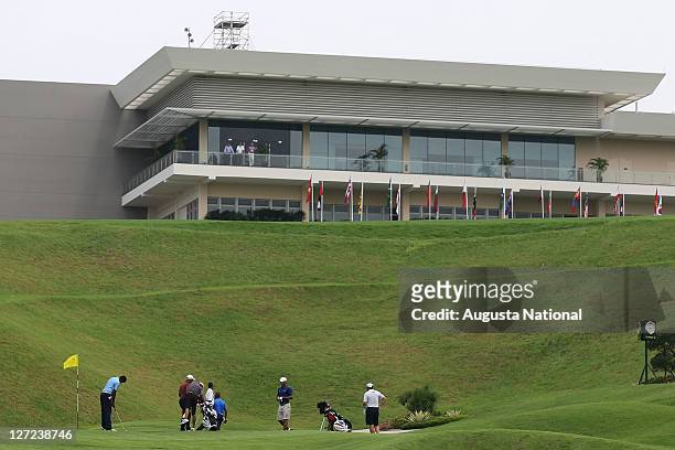 Players putt in front of the clubhouse during a practice round ahead of the 2011 Asian Amateur Championship at the Singapore island Country Club on...