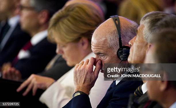 Greek Prime Minister George Papandreou and German Chancellor Angela Merkel follow a meeting of the Federation of German Industry in Berlin on...
