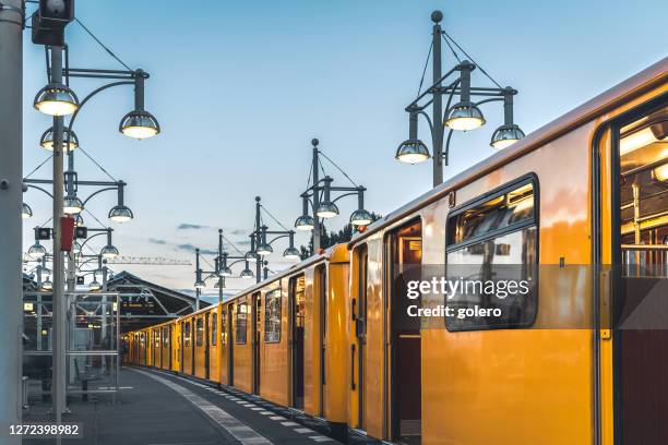 old yellow metro train in station in berlin - berlin subway stock pictures, royalty-free photos & images