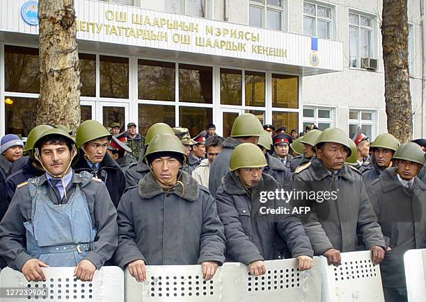 Kyrgyz police stand guard outside a government building in the southern city of Osh, which was overtaken by demonstrators protesting results of...