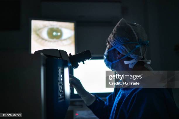 medico che fa un esame o un intervento chirurgico, guardando le immagini nel monitor - optometria foto e immagini stock