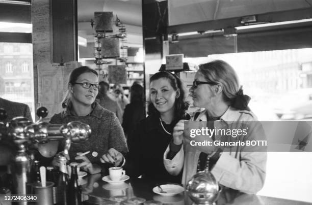 Marina Vlady au comptoir d'un café parisien avec ses soeurs Hélène Vallier et Odile Versois, en août 1966.