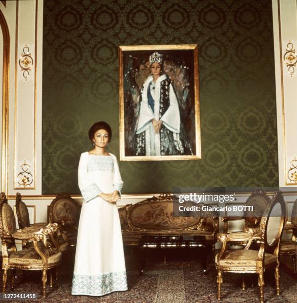 Portrait de Farah Pahlavi, impératrice d'Iran, devant un portrait réalisé lors de son couronnement, dans les années 1970.