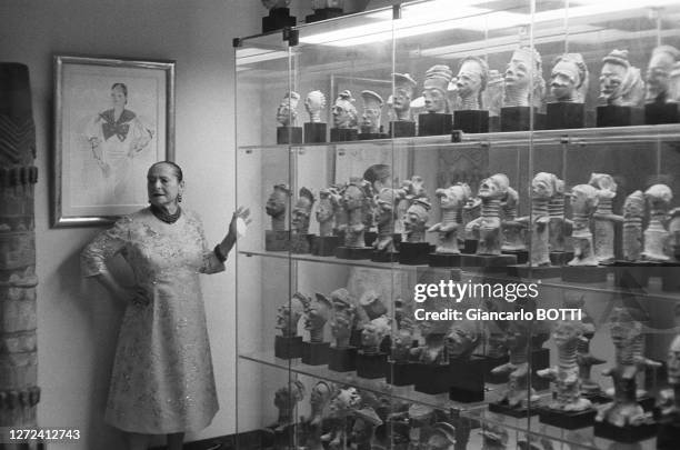 Helena Rubinstein devant sa collection de statuettes d'art africain dans son appartement sur l'Ile Saint-Louis, en juillet 1962.