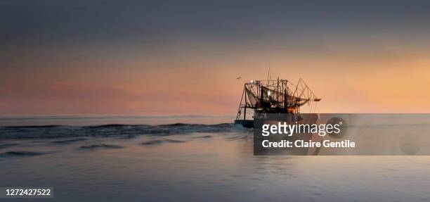 shrimping at sunset in the mississippi gulf coast - fishing boat 個照片及圖片檔
