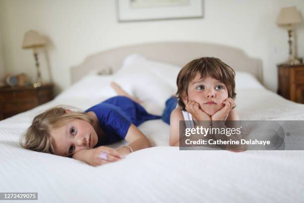 a brother and a sister boring in a bed - little brother stock pictures, royalty-free photos & images
