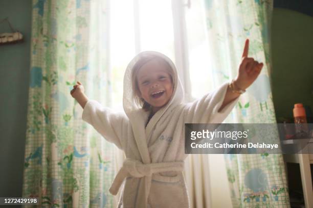 a little girl dancing in her bedroom - bademantel stock-fotos und bilder