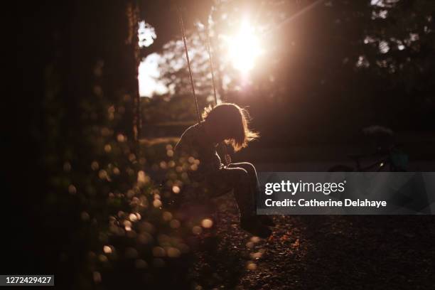 a little boy swinging in the courtyard of the house - pureté photos et images de collection
