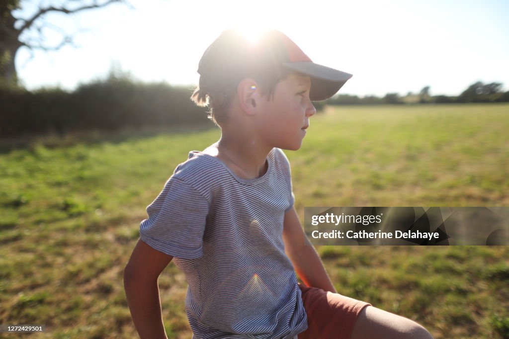 A 9 years old boy posing in a meadow