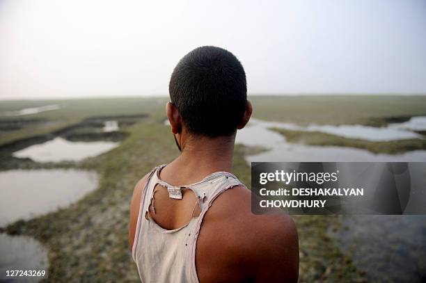 Indian farmer Srikanta Doloi gestures as he describes the loss of his ancestral farmland after it was submerged on Ghoramara Island, in the...