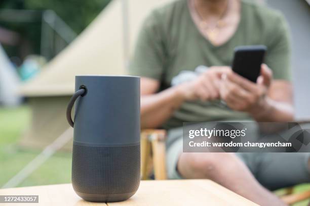 men using a smart speaker with smartphone. - bluetooth fotografías e imágenes de stock