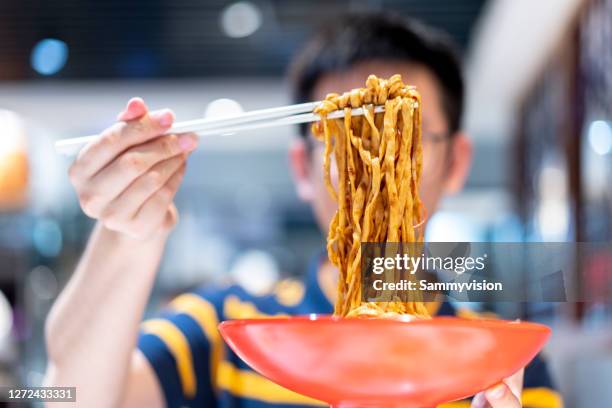 tasting chinese noodles - chinese noodles stockfoto's en -beelden