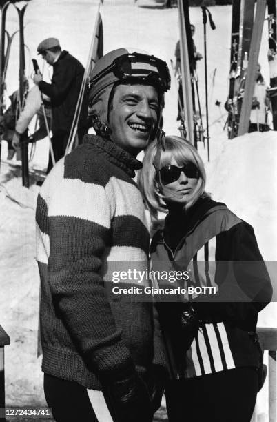 Portrait de Jean-Paul Belmondo en tenue de ski et Mylène Demongeot sur le tournage du film "Tendre Voyou", en février 1966.