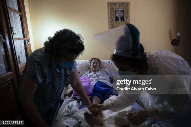 Blanca Vizan, a 22-year-old nurse, performs home health care for Celia Cazcarra, a patient who has ulcers on her legs and feet, on September 12, 2020...