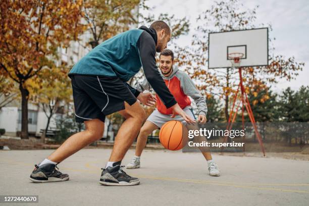 zwei freunde spielen basketball - amateur stock-fotos und bilder
