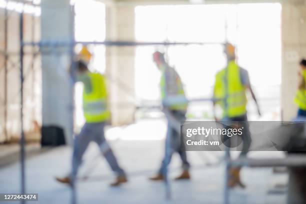 blurred workers on a construction site - defocus stock pictures, royalty-free photos & images