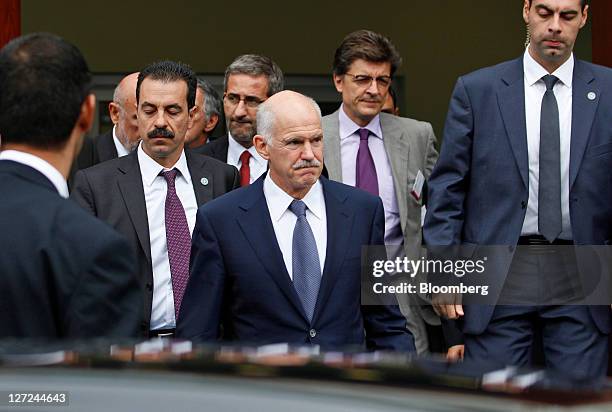 George Papandreou, Greece's prime minister, center, leaves after speaking at the BDI federation of German industries conference in Berlin, Germany,...