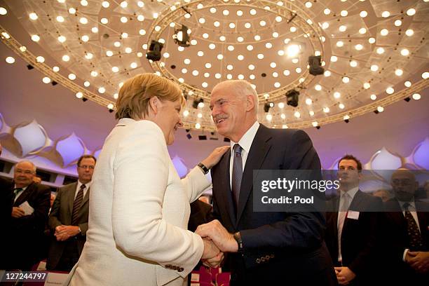 In this image provided by the German press office, German Chancellor Angela Merkel and Greek Prime Minister George Papandreou shake hands during a...