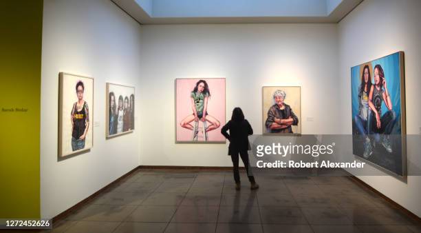 Museum visitor admires paintings by feminist artist Sarah Stolar at the New Mexico Museum of Art in Santa Fe, New Mexico.