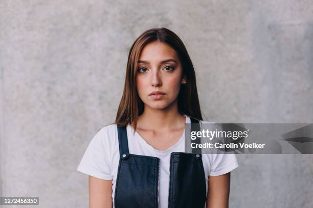 frontal headshot of a young hispanic woman aged 20-24 years against a concrete wall, munich, germany - human face frontal stock pictures, royalty-free photos & images