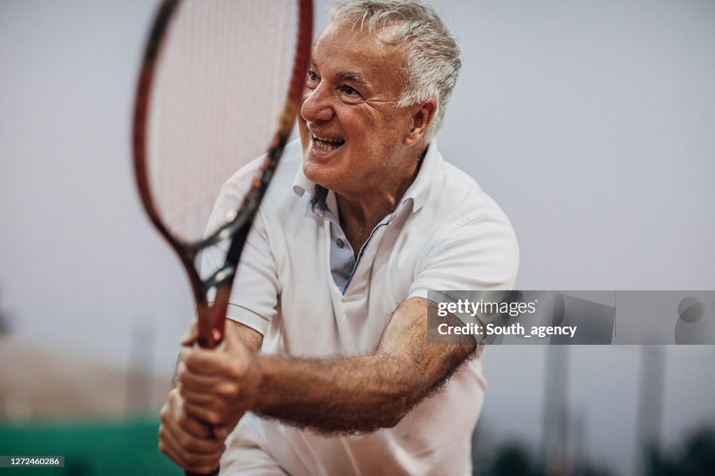 Senior man playing tennis